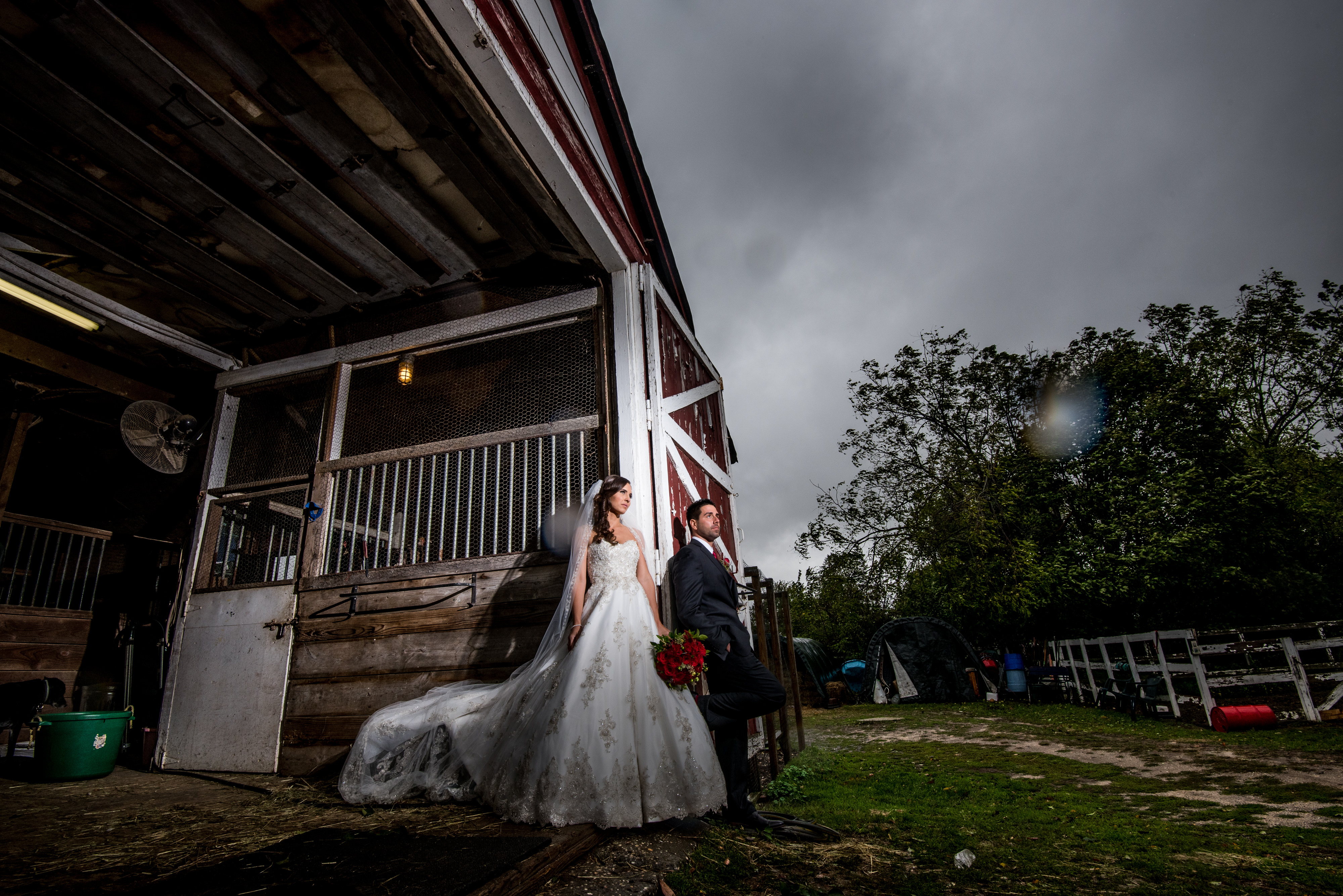 Bridge and groom pose in front of a barn | Lotus Wedding Photography
